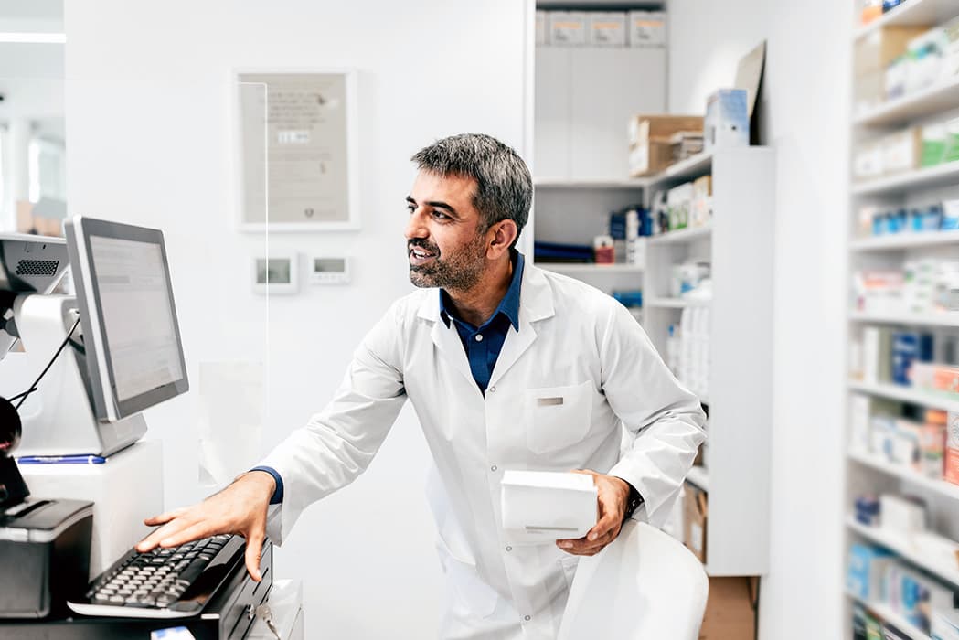 A pharmacist using RxSense's GlobalBIN, highlighting how pharmacies can support smarter decision-making and help lower prescription drug costs with RxSense solutions.