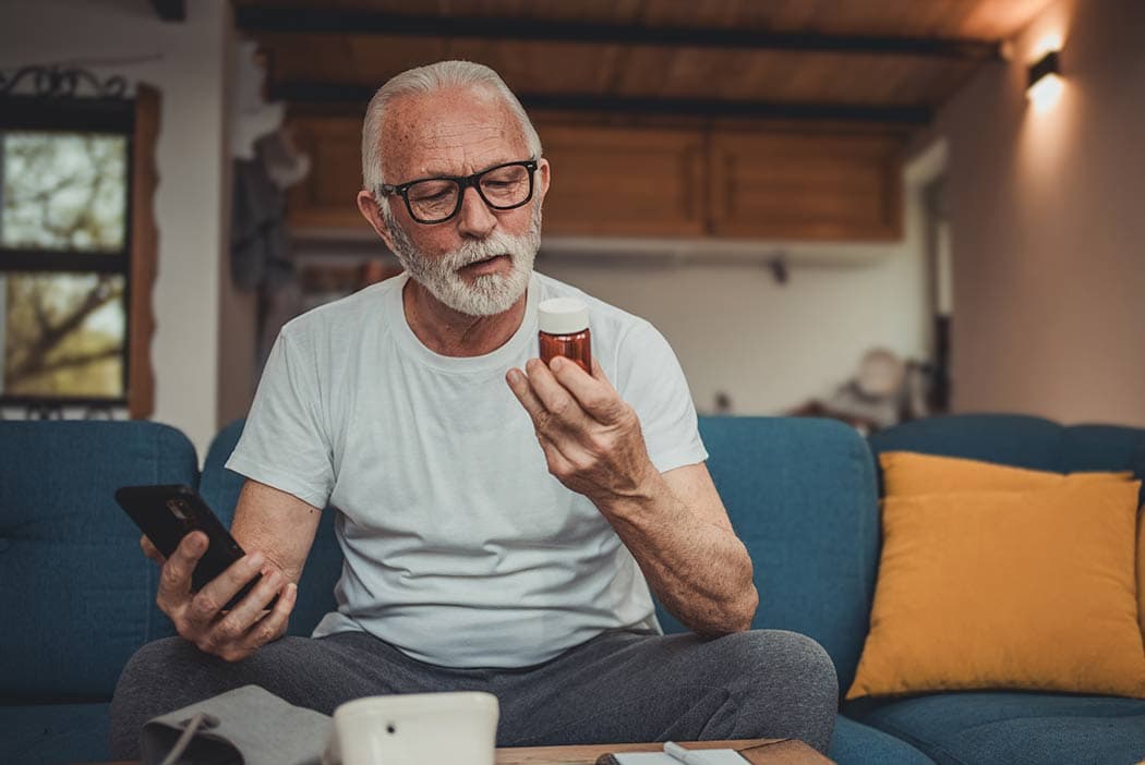 A man is looking up the cost of his prescription using SingleCare and comparing his new lower price.