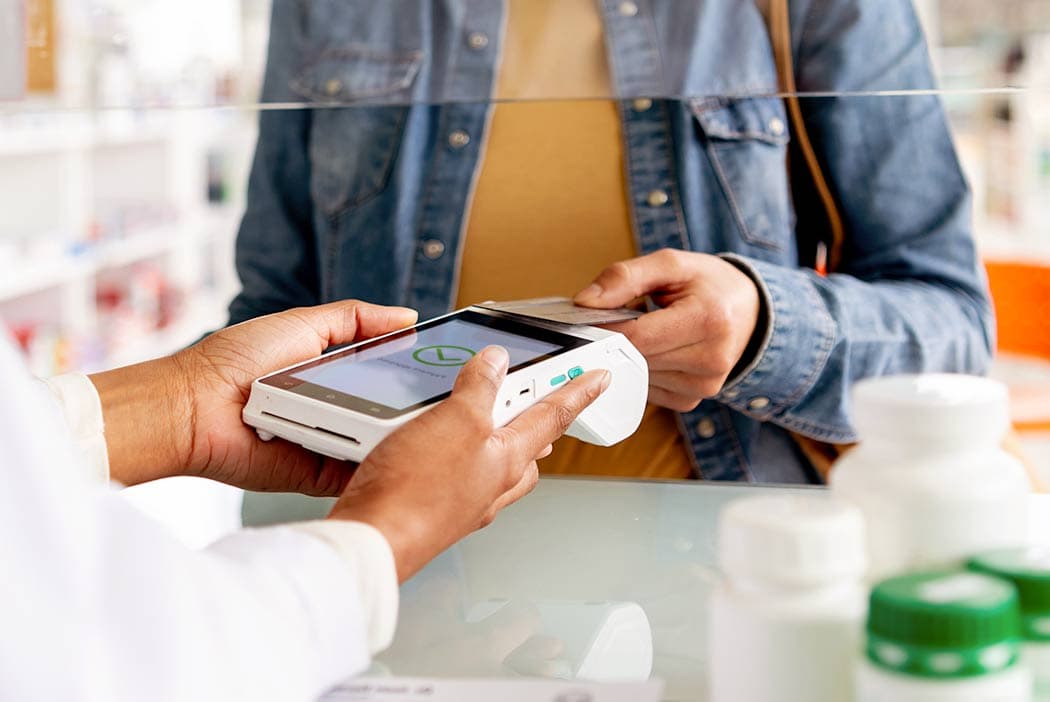 A customer pays for their prescription at a pharmacy.