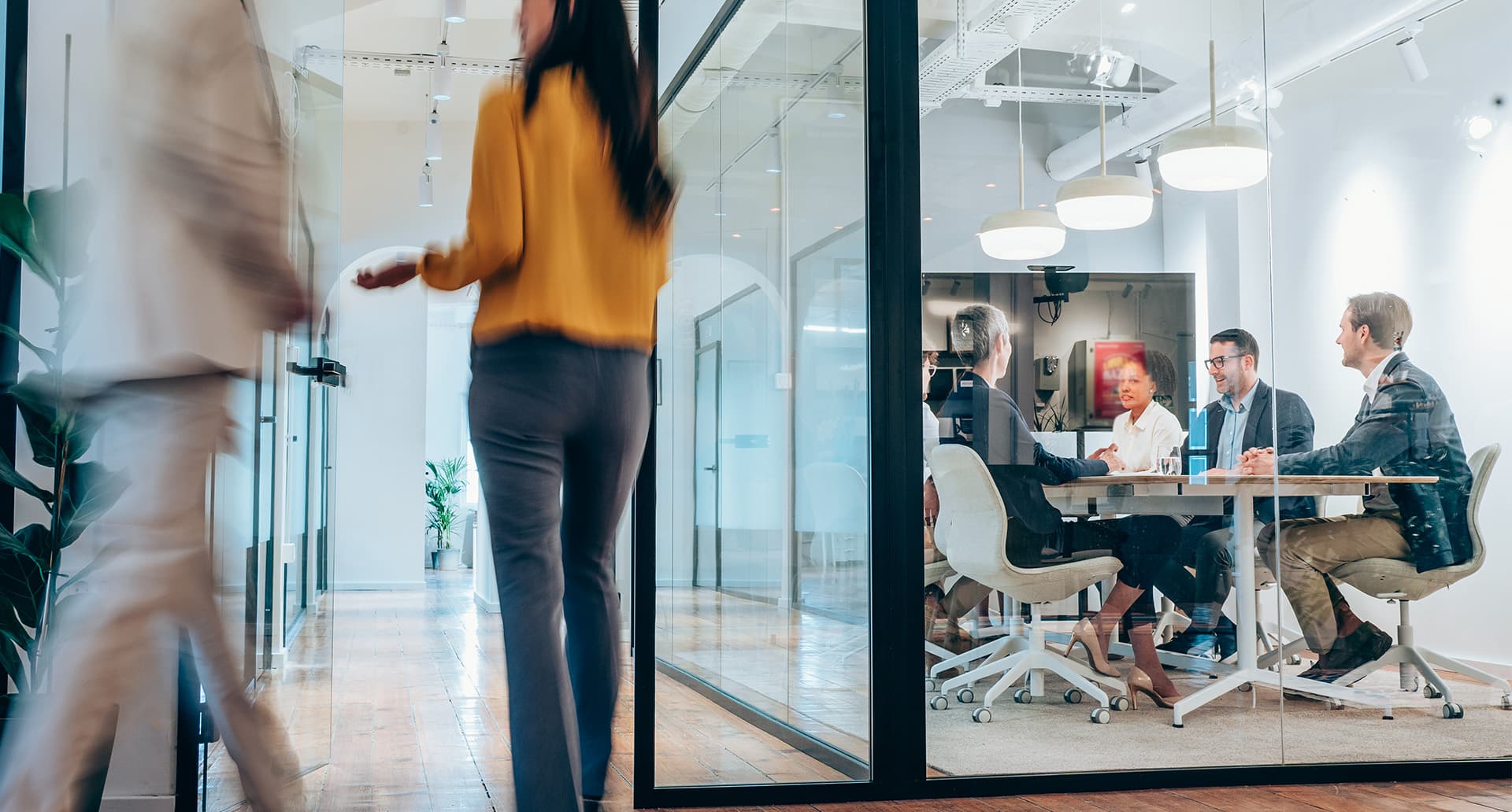 A group of individuals working together to discuss pharmacy benefit management in a brightly lit office space.